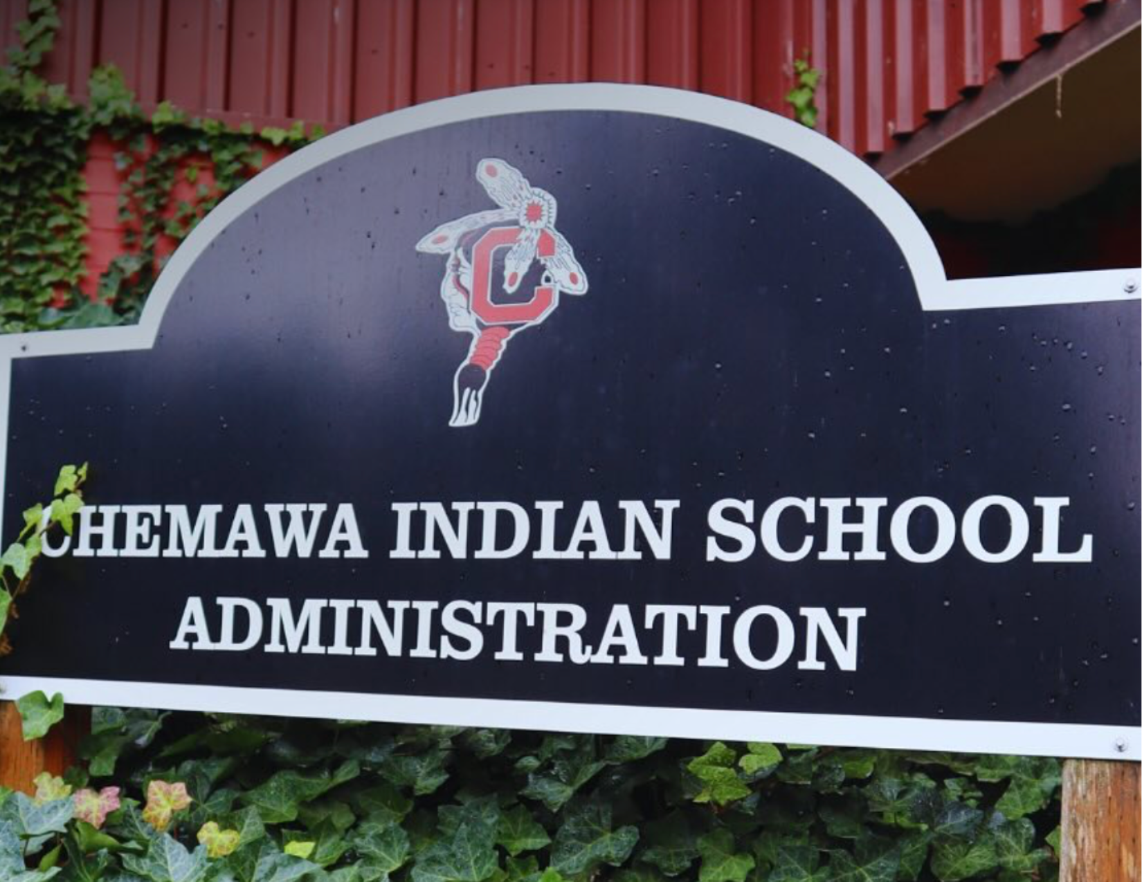 The Chemawa Indian School administration sign is surrounded by ivy vines.